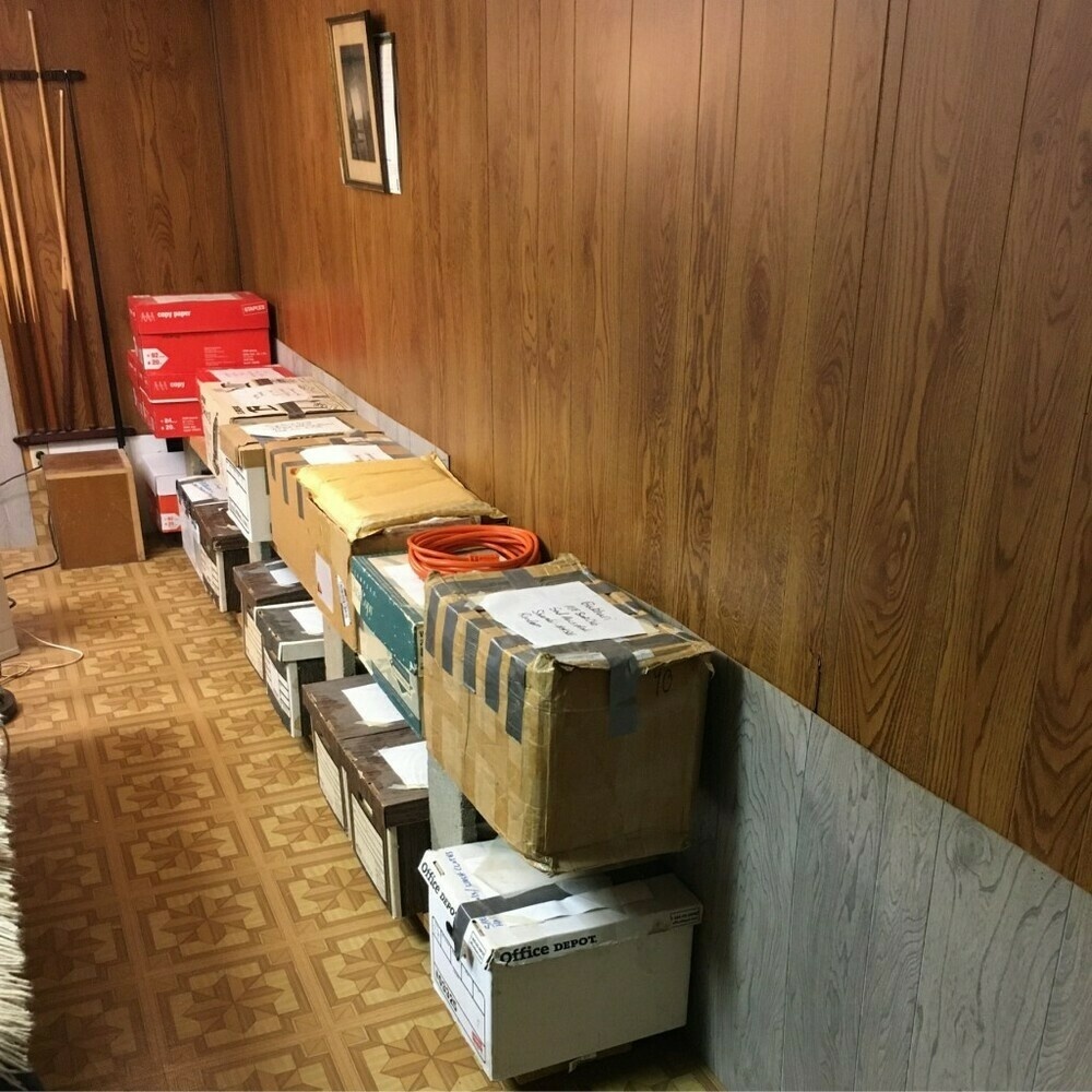 A 12-ft double-decker bookshelf filled with boxes of books.