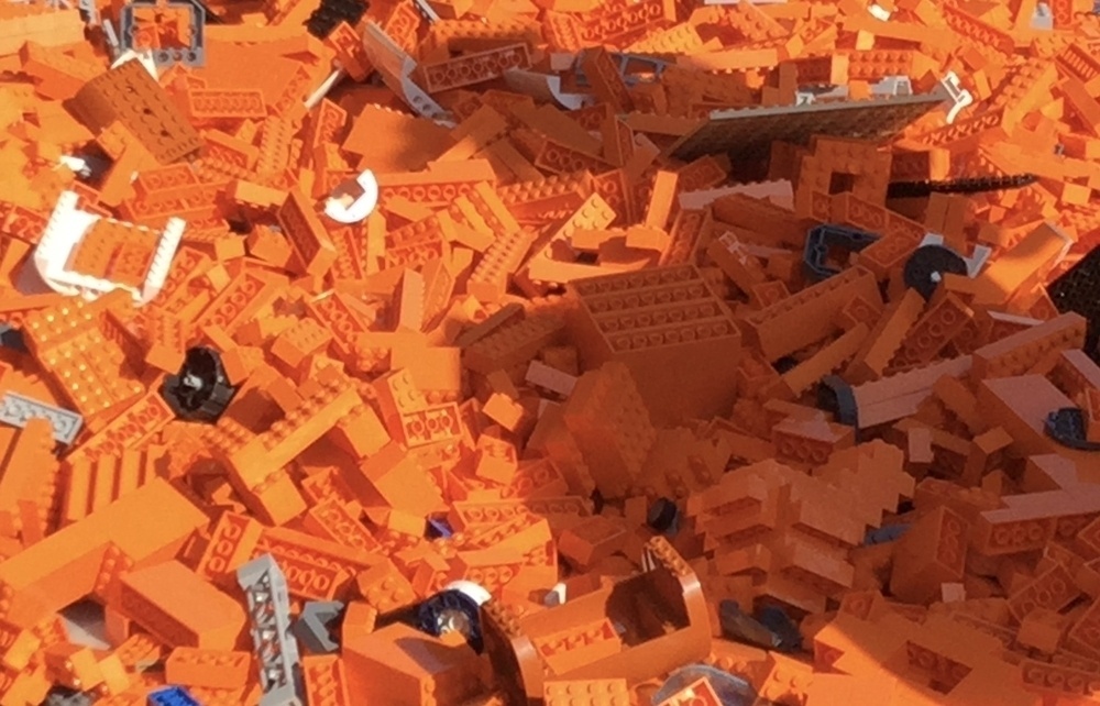 A large number of LEGOs, mostly orange. 