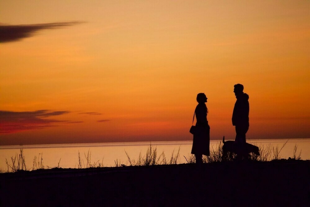 A cpuple talking as the sun goes down on Shoreham Beach. 