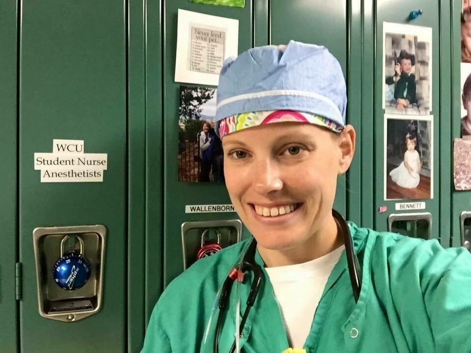 Nurse by lockers smiling at camera