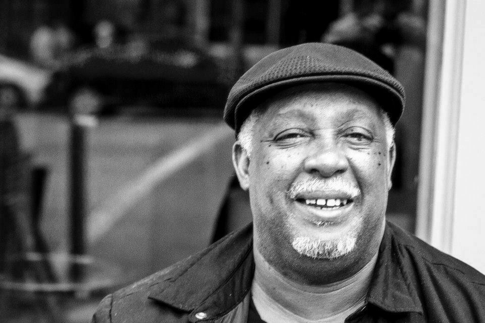 A man in a flat cap smiling