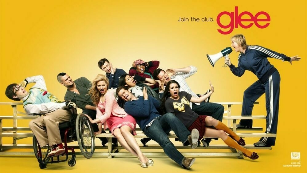 Poster of Sue with a bullhorn yelling at the rest of the Glee cast who are sitting on bleachers