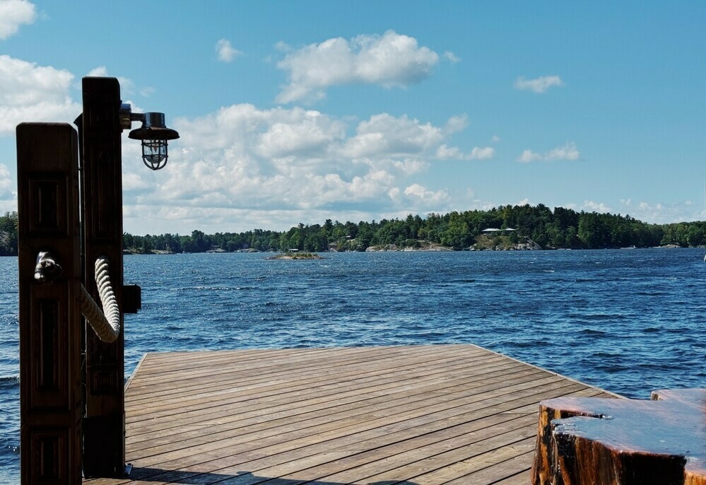 A lakeside dock overlooking the choppy lake with trees in the background