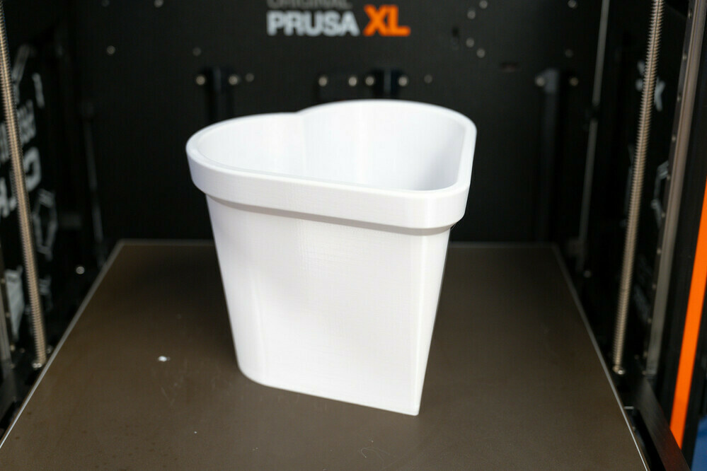 Photo of a 3D printed flower pot in a heart shape.