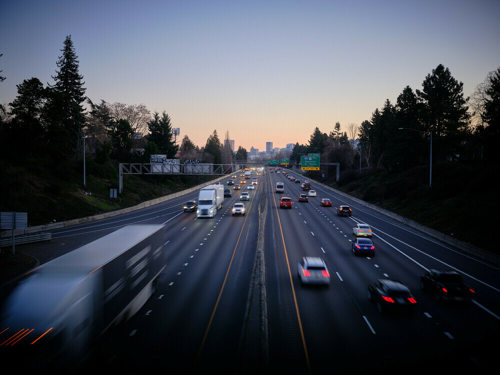 Cars and trucks are traveling on Interstate 5 through the city of Portland, Oregon.