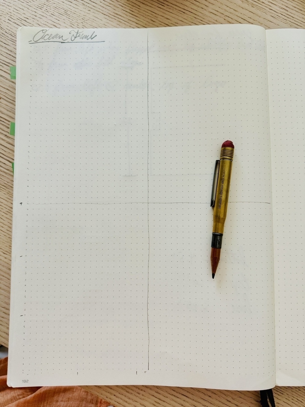A dotted notebook lies open with a mechanical pencil placed on the right page and the left page labeled with the heading "Ocean Front".