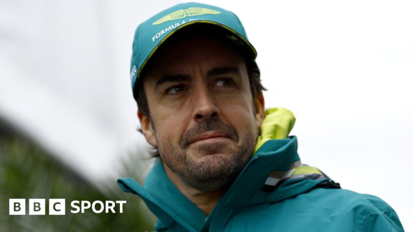 Head shot image of Fernando Alonso wearing an Aston Martin F1 baseball cap