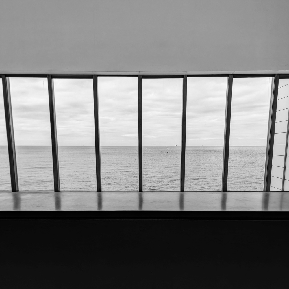 The see viewed through tall rectangular windows from the balcony of the Turner Contemporary gallery, in black and white