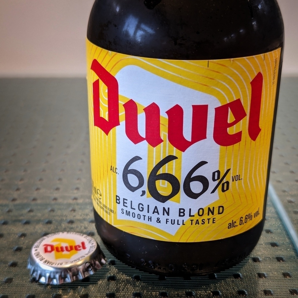 A bottle of Duvel 6.66% beer alongside it’s removed cap