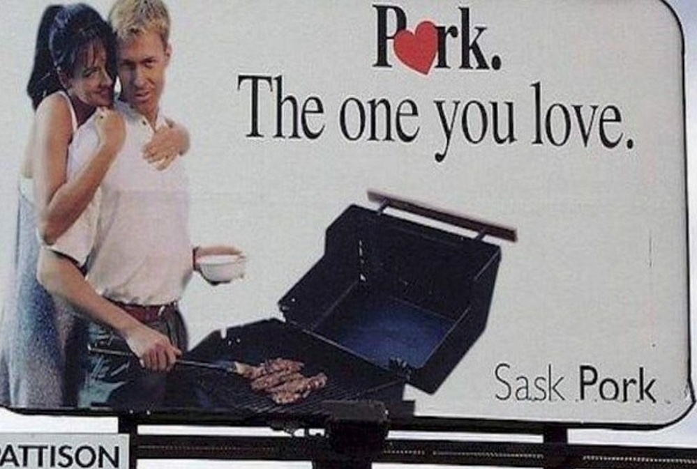 Photo of a billboard from Saskatchewan reading “Pork. The One you love” showing a man barbecuing meat on a grill while a woman hugs him from behind.