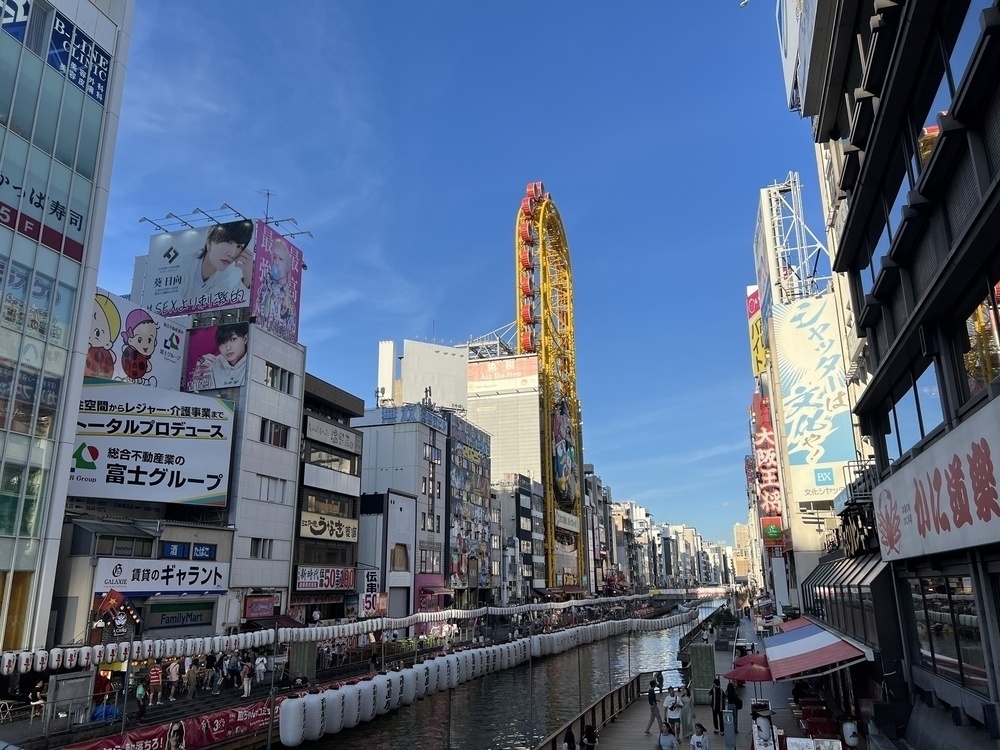 Dotonbori canal on a bright day under a blue sky 