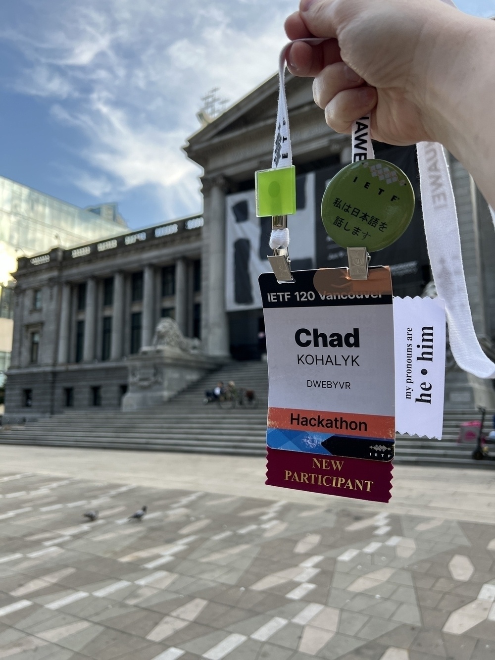 Chad’s ratty IETF badge held up with the Vancouver Art Museum in the background