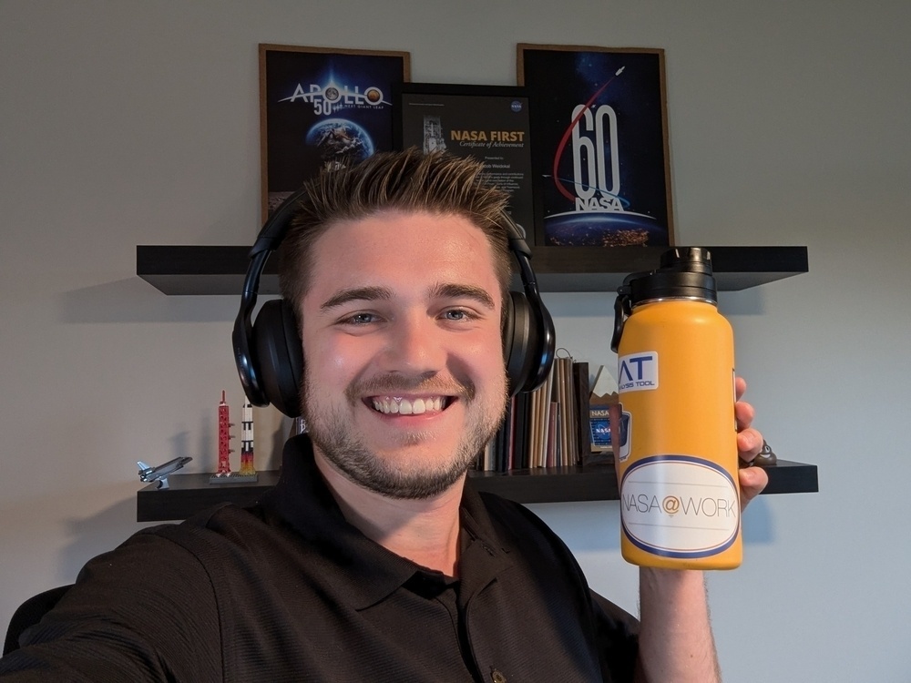 Jake holding his water bottle with the sticker displaying on the front of it