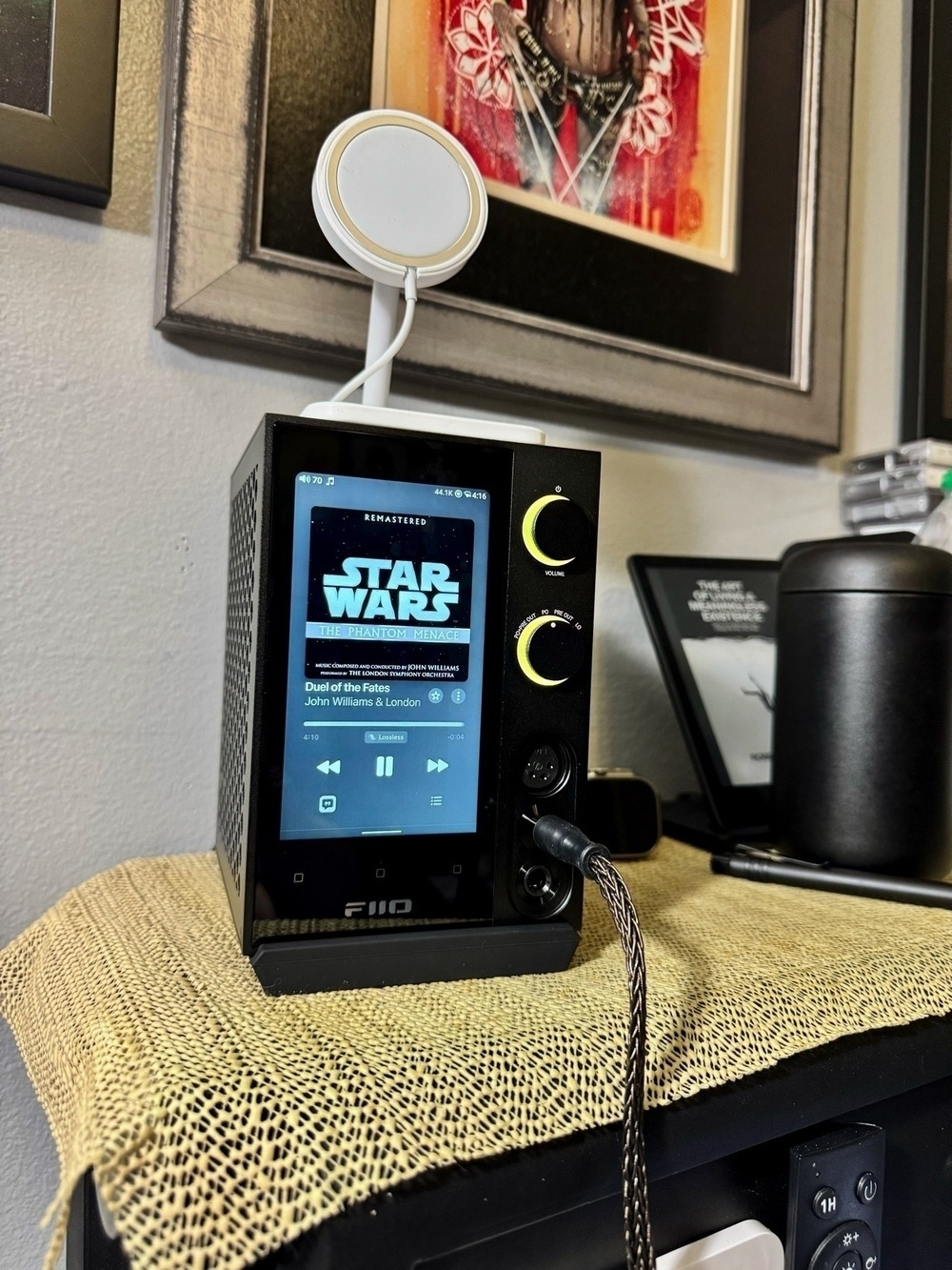 FIIO R7 desktop audio streamer sitting on a headboard, display a Star Wars album currently playing.