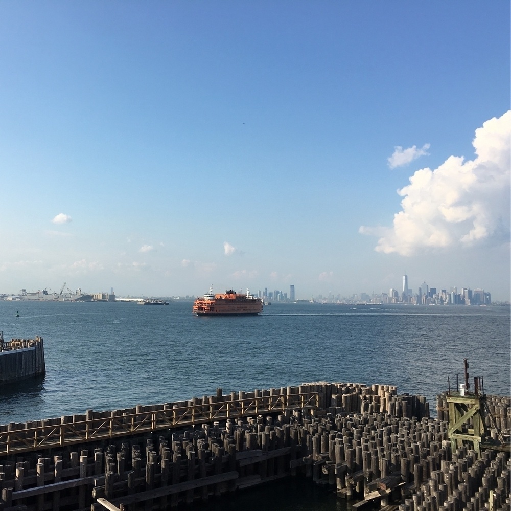 Photo of Manhattan from Staten Island, with water and a ferry in the center