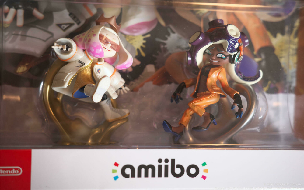 Two amiibo figurines inside a packaging box featuring characters with distinct outfits and hairstyles.