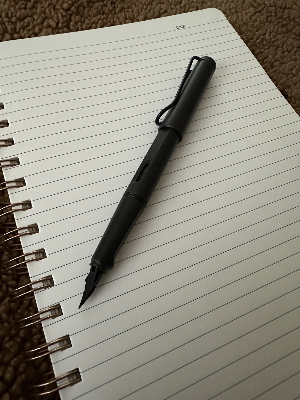 A Lamy Safari Fountain Pen on a large, spiral-bound notebook. 