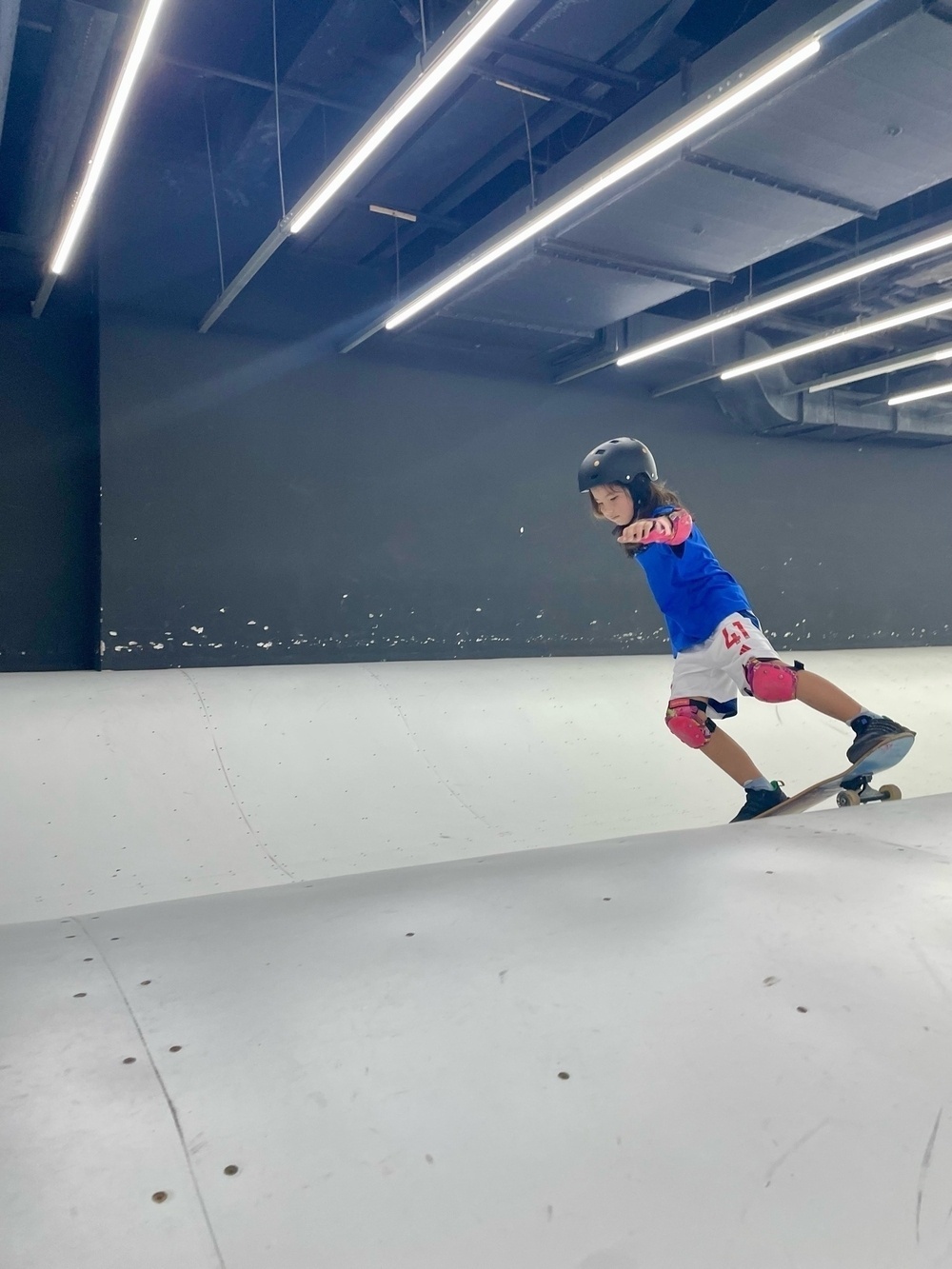 Girl skateboarding on a white ramp