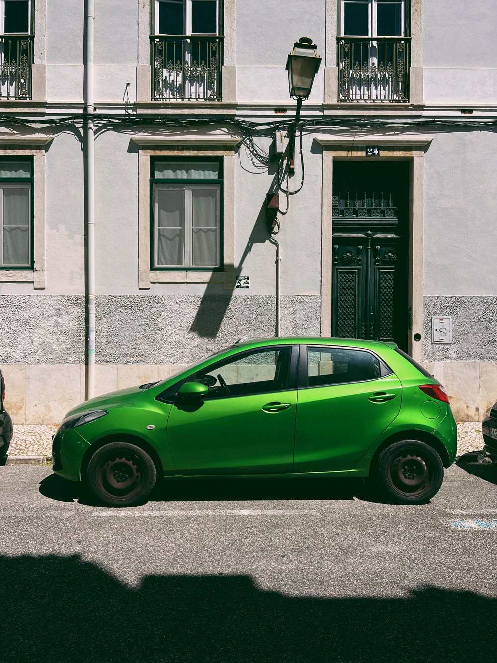 a green car parked in the street.