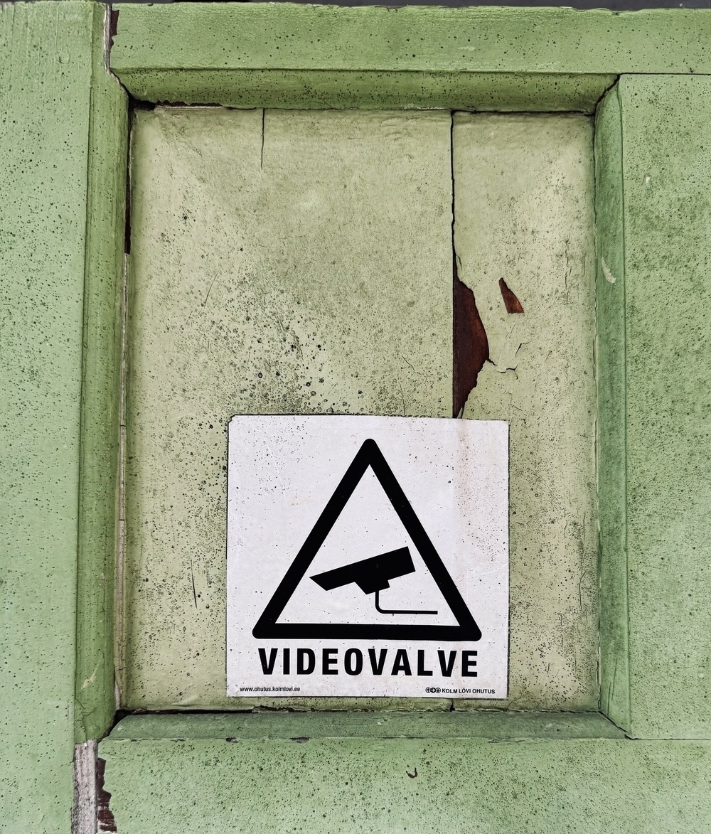 A panel on a green door with a sign that says “VIDEOVALVE” under an icon of a CCTV camera.