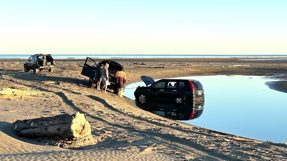 Car stuck in river remnant.