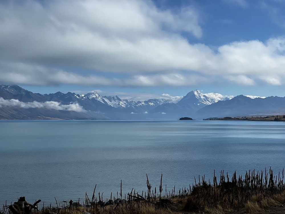 High snowy mountain behind lake. 