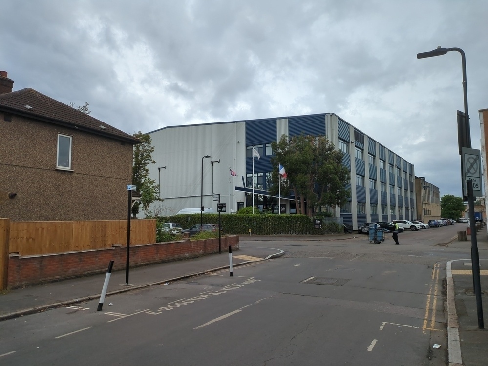 Photo of junction of HGV Access Roads with new 'E-Scooter and Cycle Hire' road markings and two black and white bollards