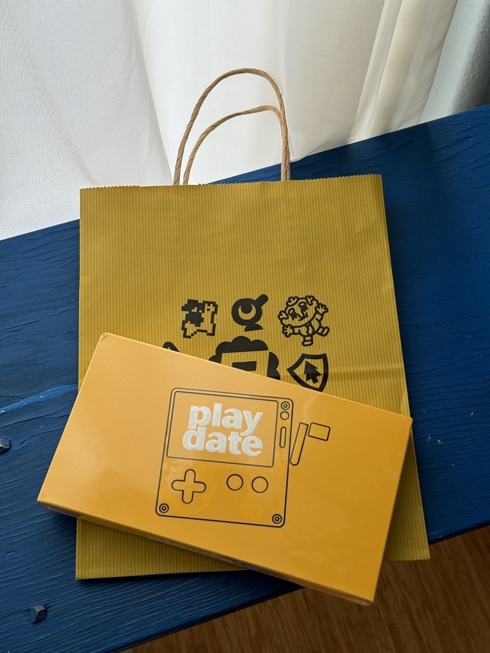 Bright yellow package and bag on a blue bench. 