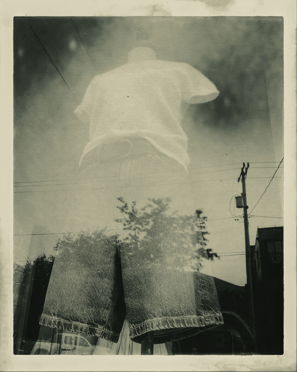 Female mannequin with shorts and short sleeve top in shop window. Vintage black and white filter applied.