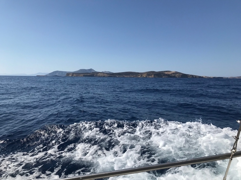 View from the boat (with wake) of the waves, with Ano Koufonisi and Keros visible in the background