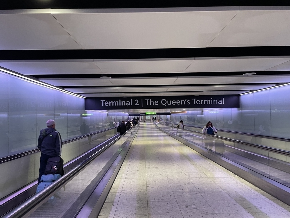 A walkway at LHR showing a sign saying “Terminal 2 The Queen’s Terminal”
