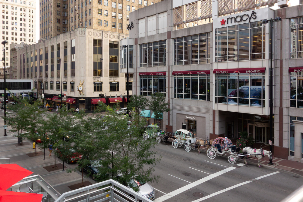 A line of horse drawn carriages outside a department store that would eventually close in the heart of Cincinnati, Ohio - Sony RX100