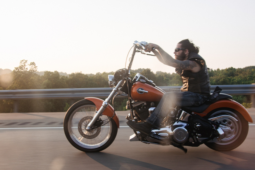 Motorcycle with tall handbags with a bearded rider on the highway - Olympus E-M5