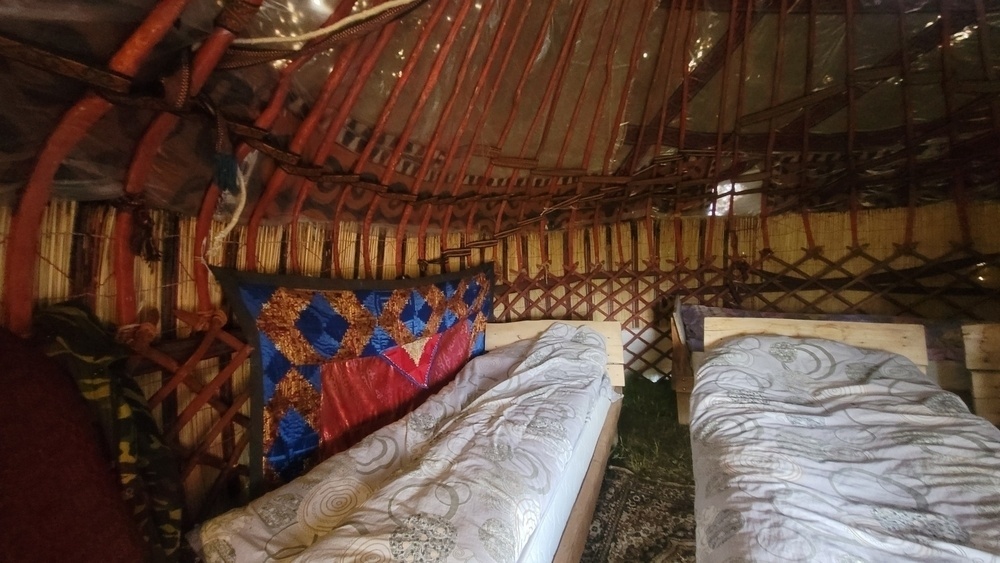 3 wooden frame twin beds inside a yurt