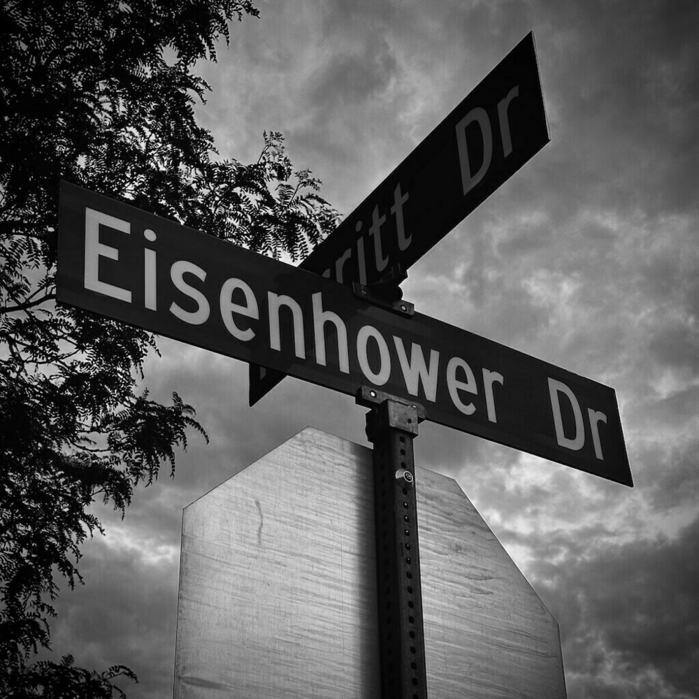 Street signs above a stop sign with clouded sky, Black and White