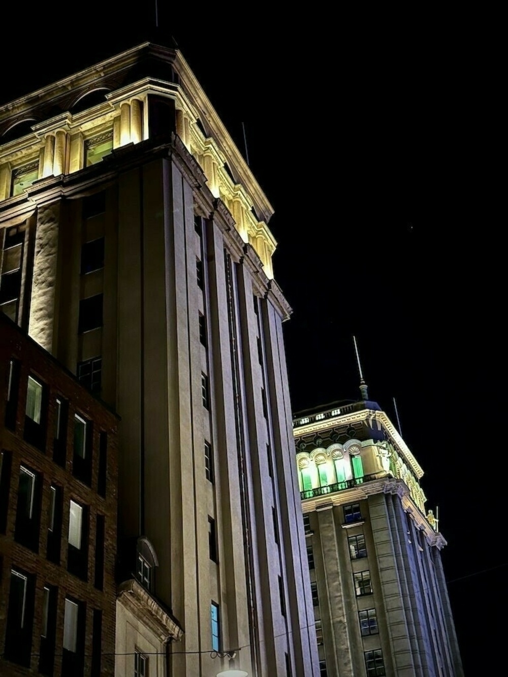 Night time lit building with dual towers. 