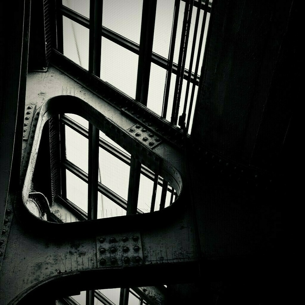 Light shining through glass ceiling panels with steel beams. Black and White