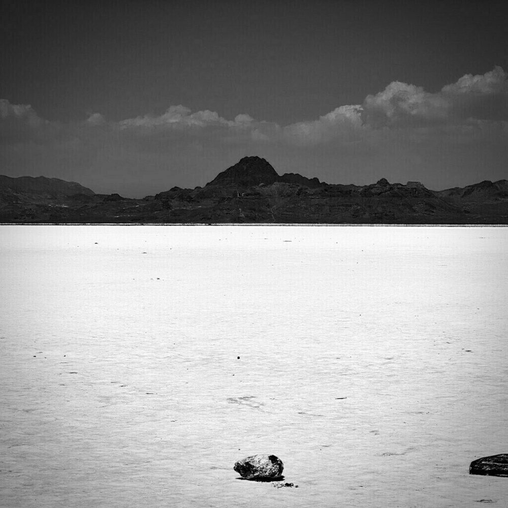 Bonneville Salt Flats. Mountains in the distance. Rocks in the foreground. 