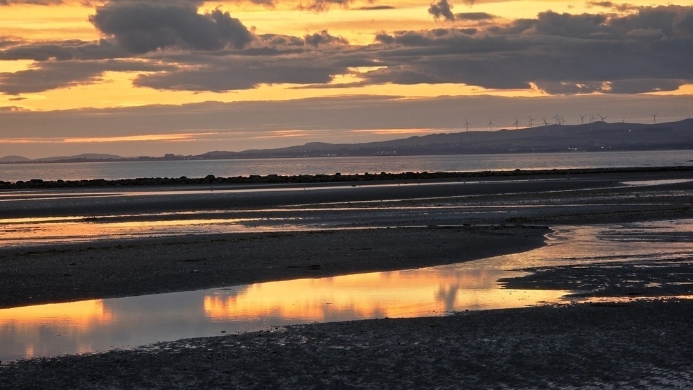Sunset reflections on the beach in pools of water