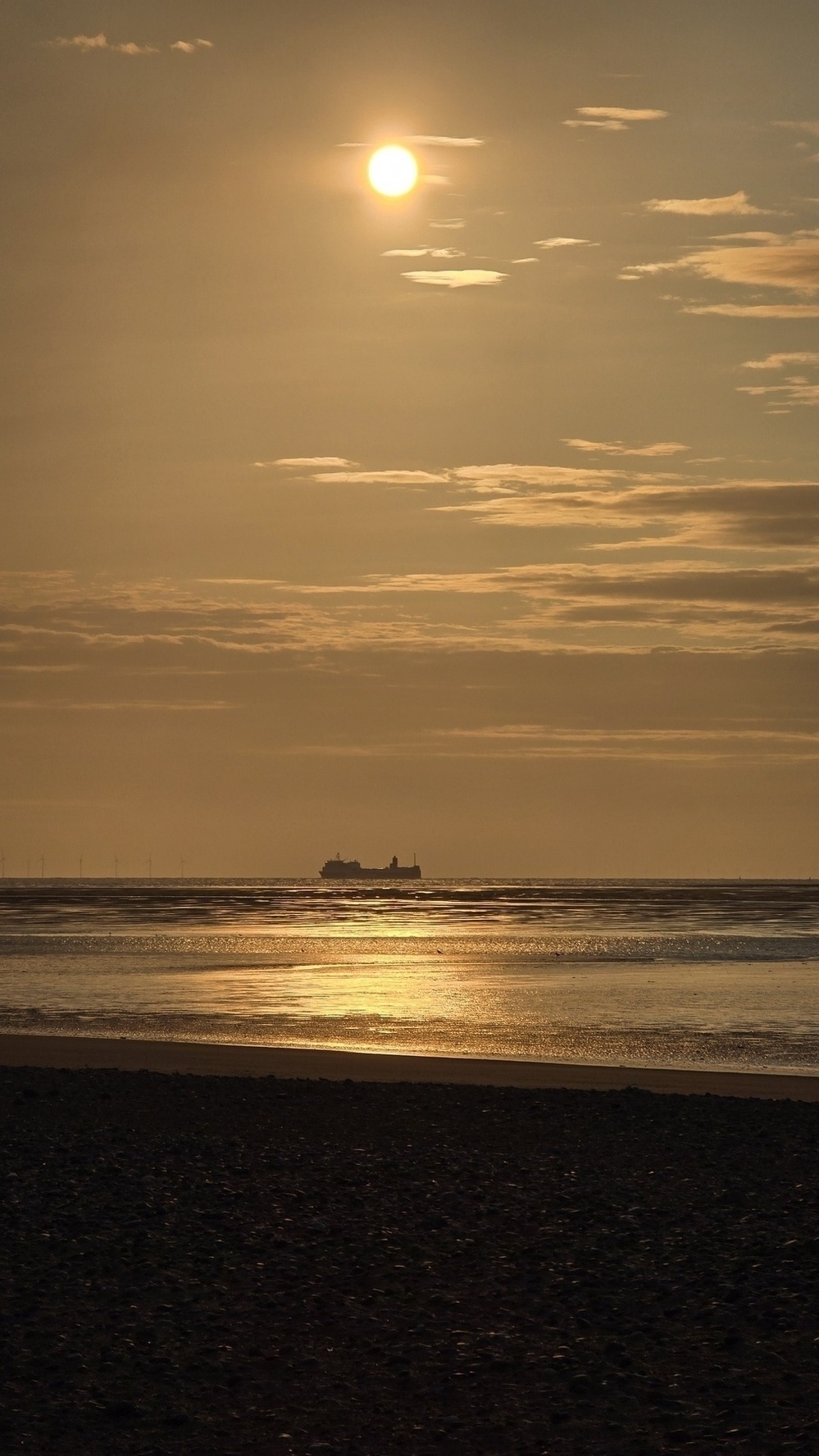 Golden sunset over the sea with a ferry in the distance