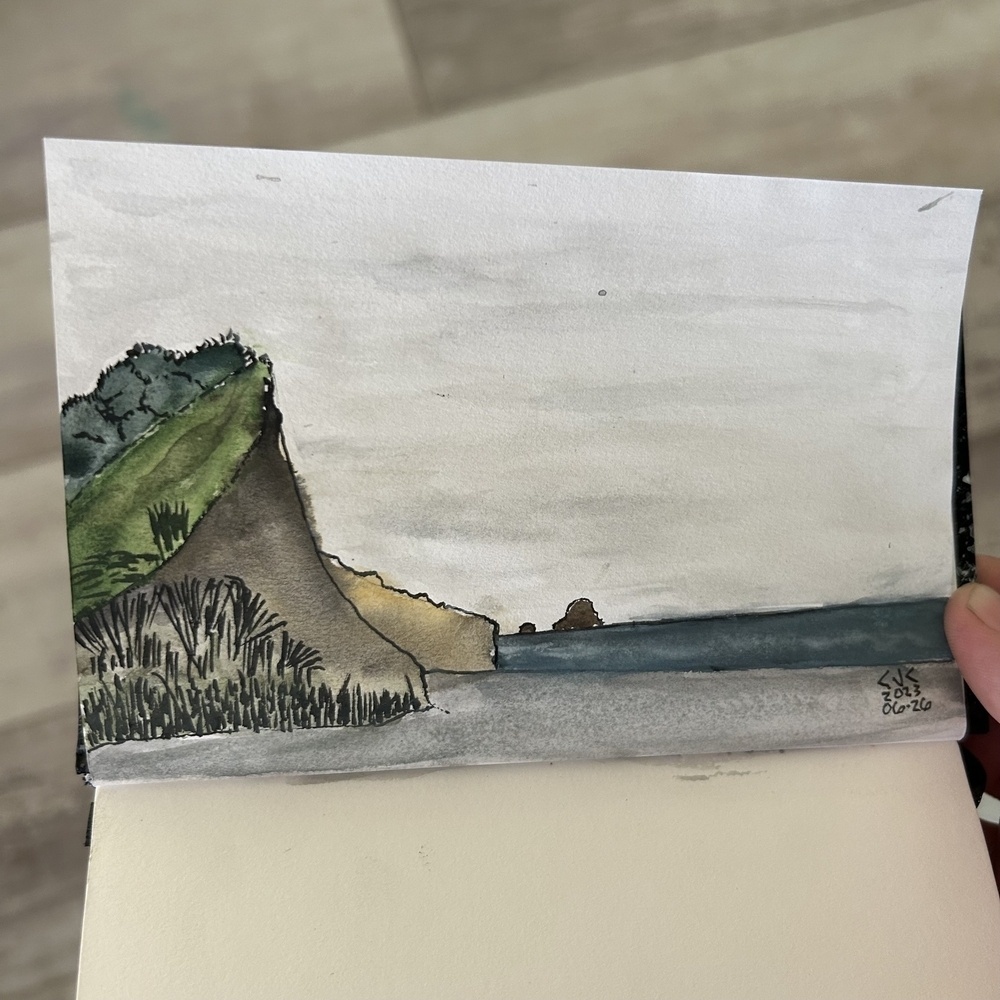 Watercolor painting of a beach and cliffs