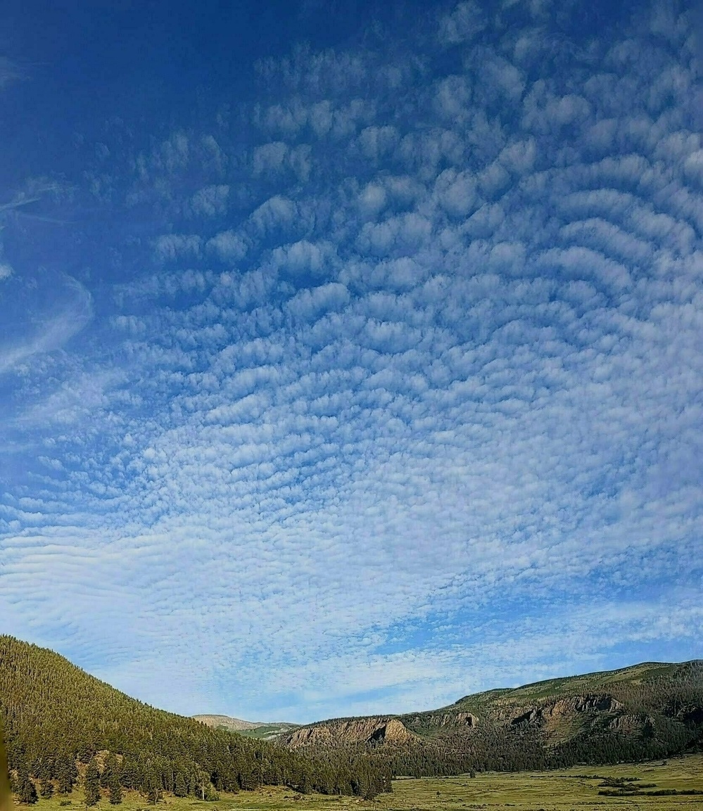 Mountain ridgeline with striated clouds in the sky above