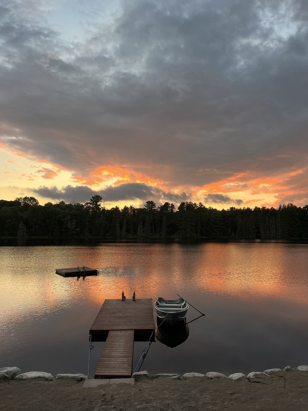 Sunset over a lake with rowboat in the foreground 