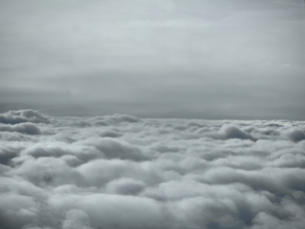 Grey skies and fluffy clouds stetching meeting at the horizon.