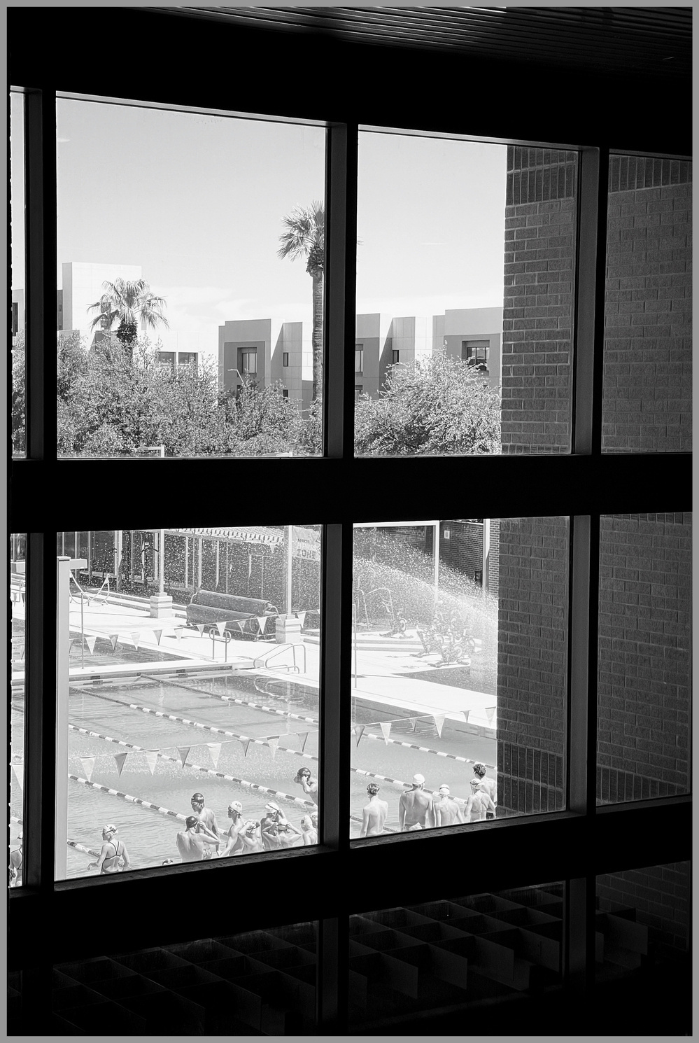 Snapshot of university swim team before practice, photographed through a window.