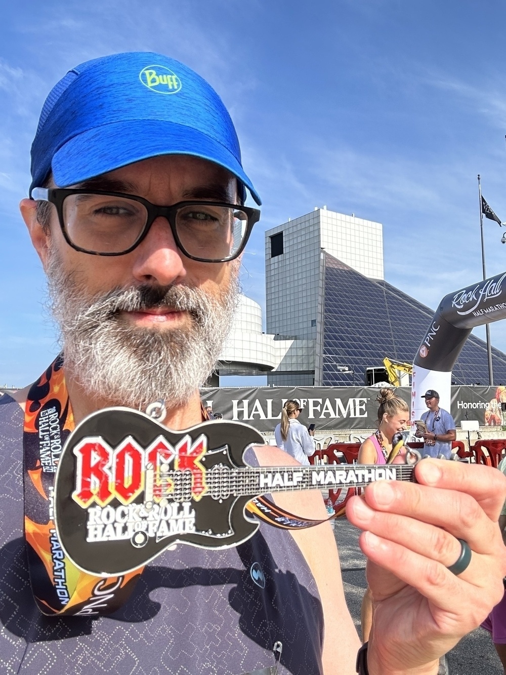 Me, in front of the Rock Hall, holding up my half marathon finisher medal, which is a guitar almost the size of my face. 