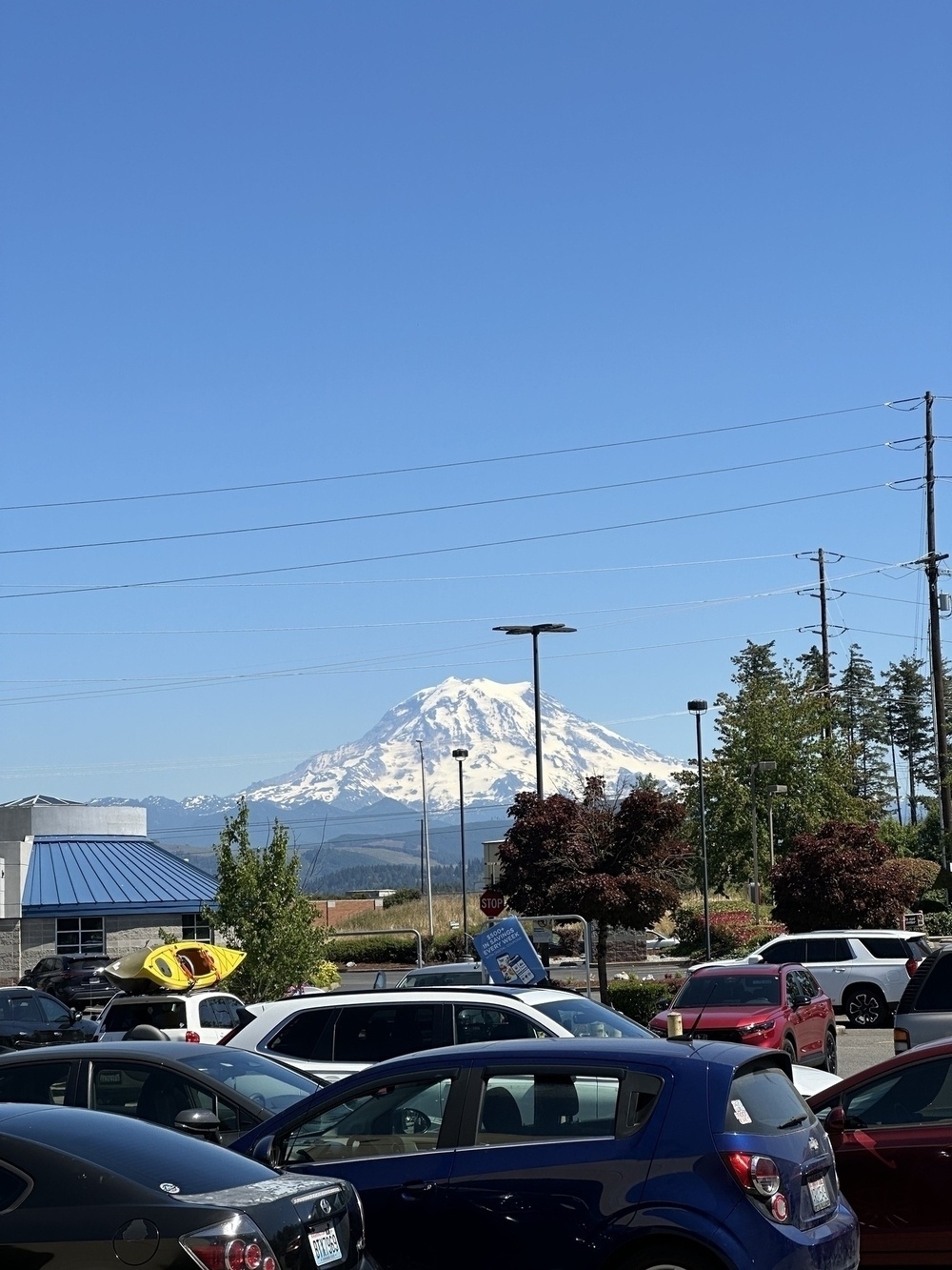 Mount Rainer looms in the background over a parking lot full of cars