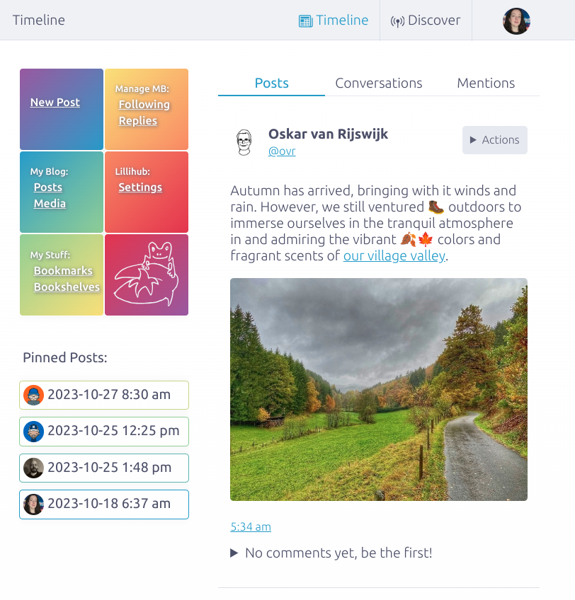 screenshot of the Lillihub Micro.blog web client. Shows timeline screen with navigation bar and the top and a colorful rainbow sidebar menu. The main column of text is a post about autumn with a picture of road with trees along the side with fall colors.