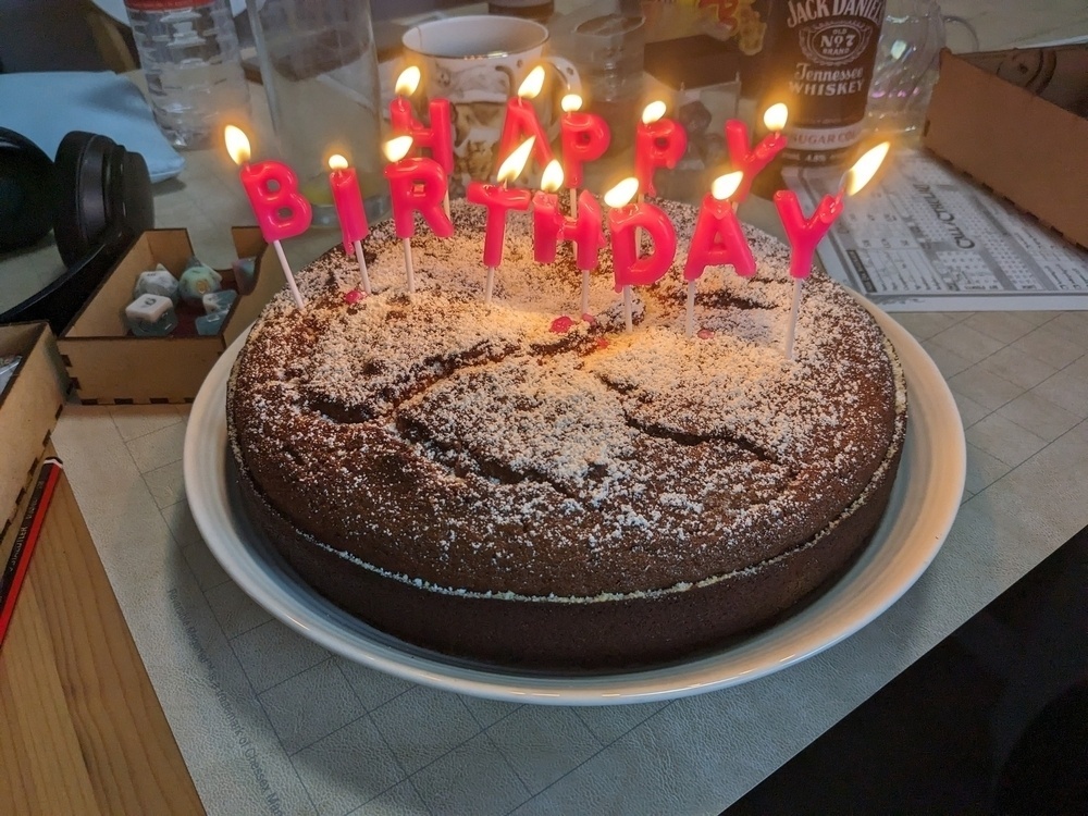 Birthday Cake with lit candles spelling out happy birthday