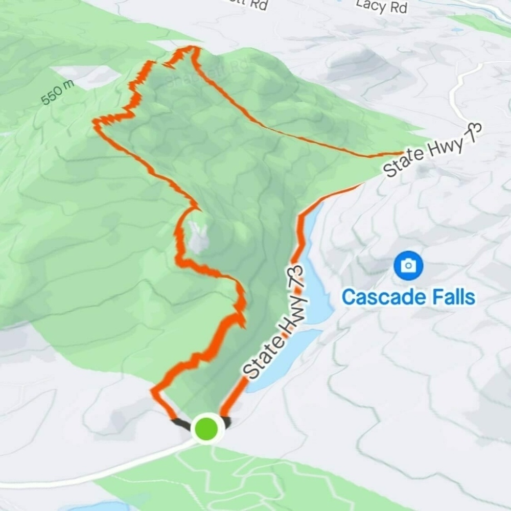 A digital map showing a highlighted hiking trail (in red) through green terrain, marked with a blue location tag labeled &ldquo;Cascade Falls,&rdquo; near a road labeled &ldquo;State Hwy 73.&quot;